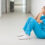Nurse sitting in a corridor while holding her head in a hospital