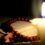 Candle burning on the background of the holy book and a cross